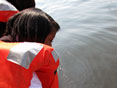 Senior Tamara McCoy lowers a secchi disk to test for water clarity.