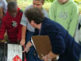 Students examine a label on a barrel